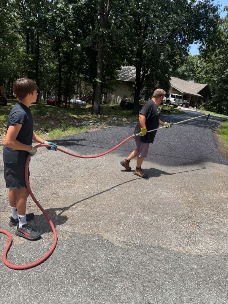 NextGen crew applying sealcoat to a residential driveway