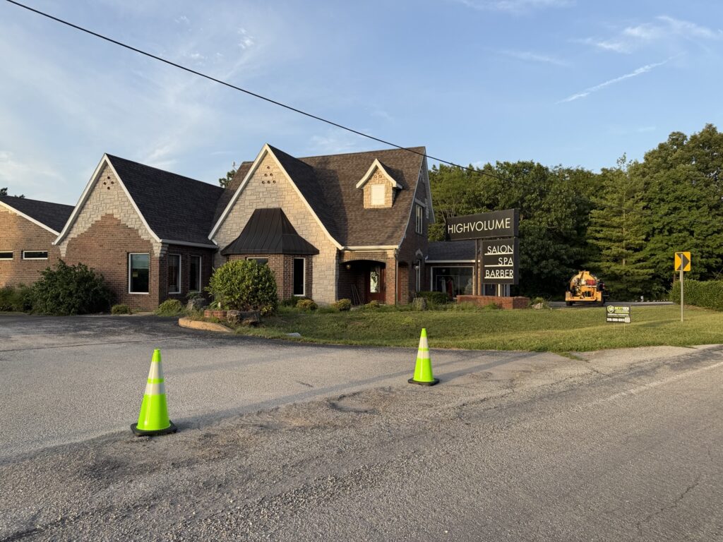 High Volume Salon parking area staged with traffic-control cones before pavement maintenance