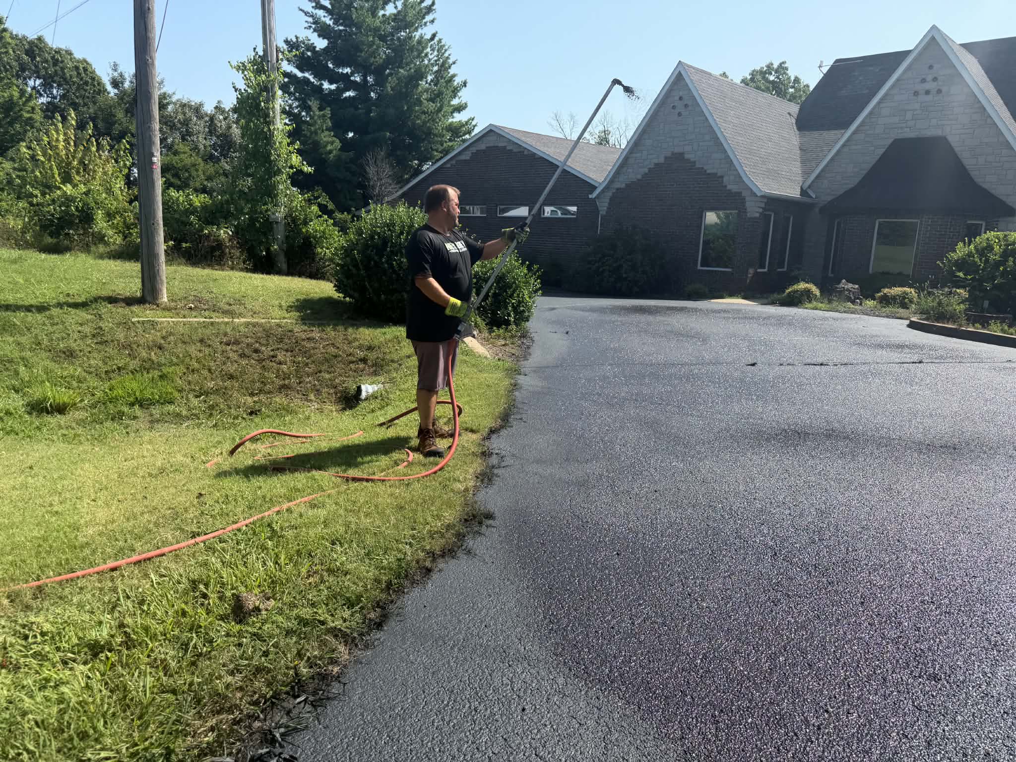 Clean Edges and Controlled Commercial Sealcoating NextGen crew applying sealer along a curved commercial pavement edge