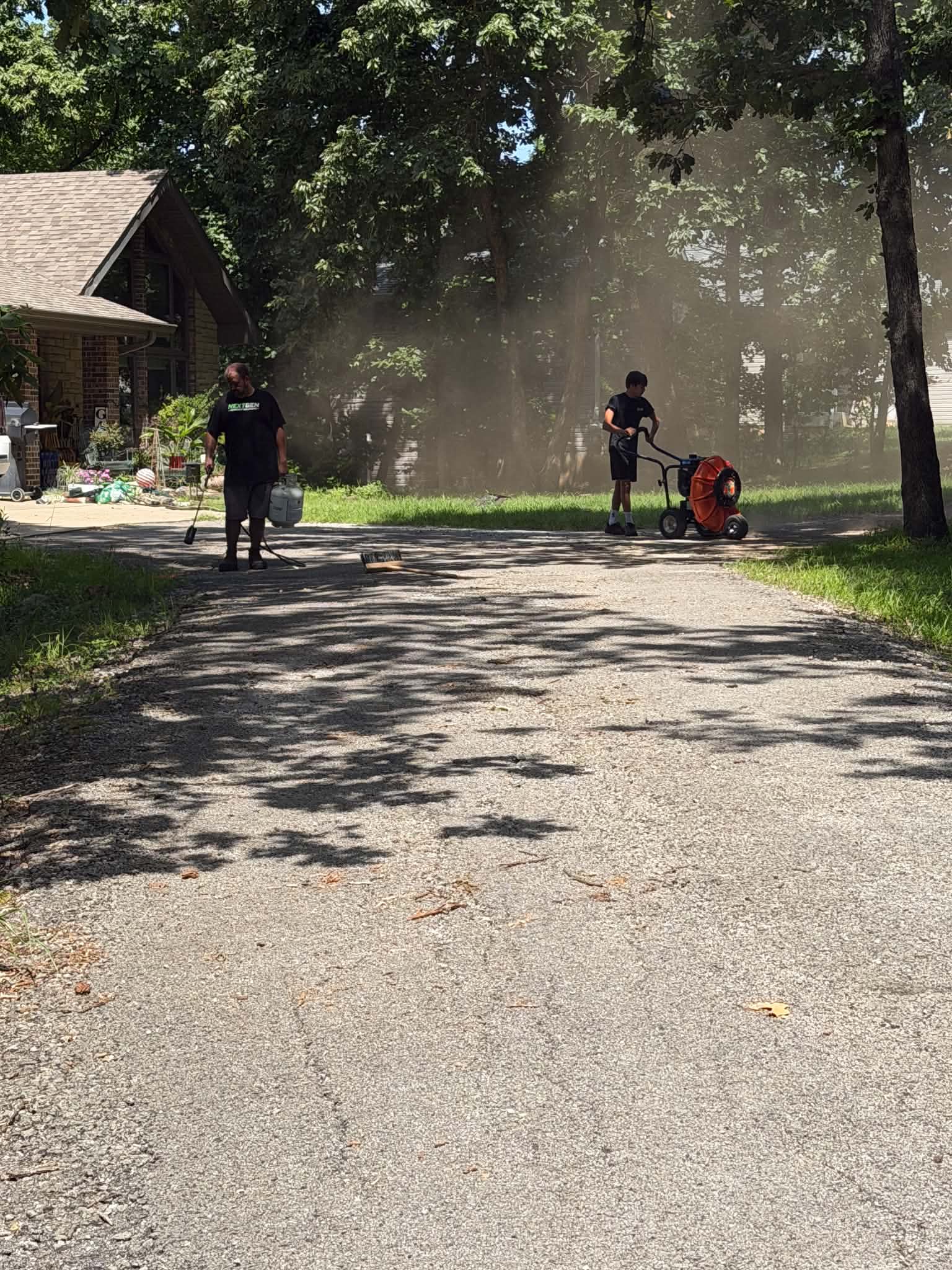 NextGen crew preparing a wooded Missouri driveway before sealcoat application