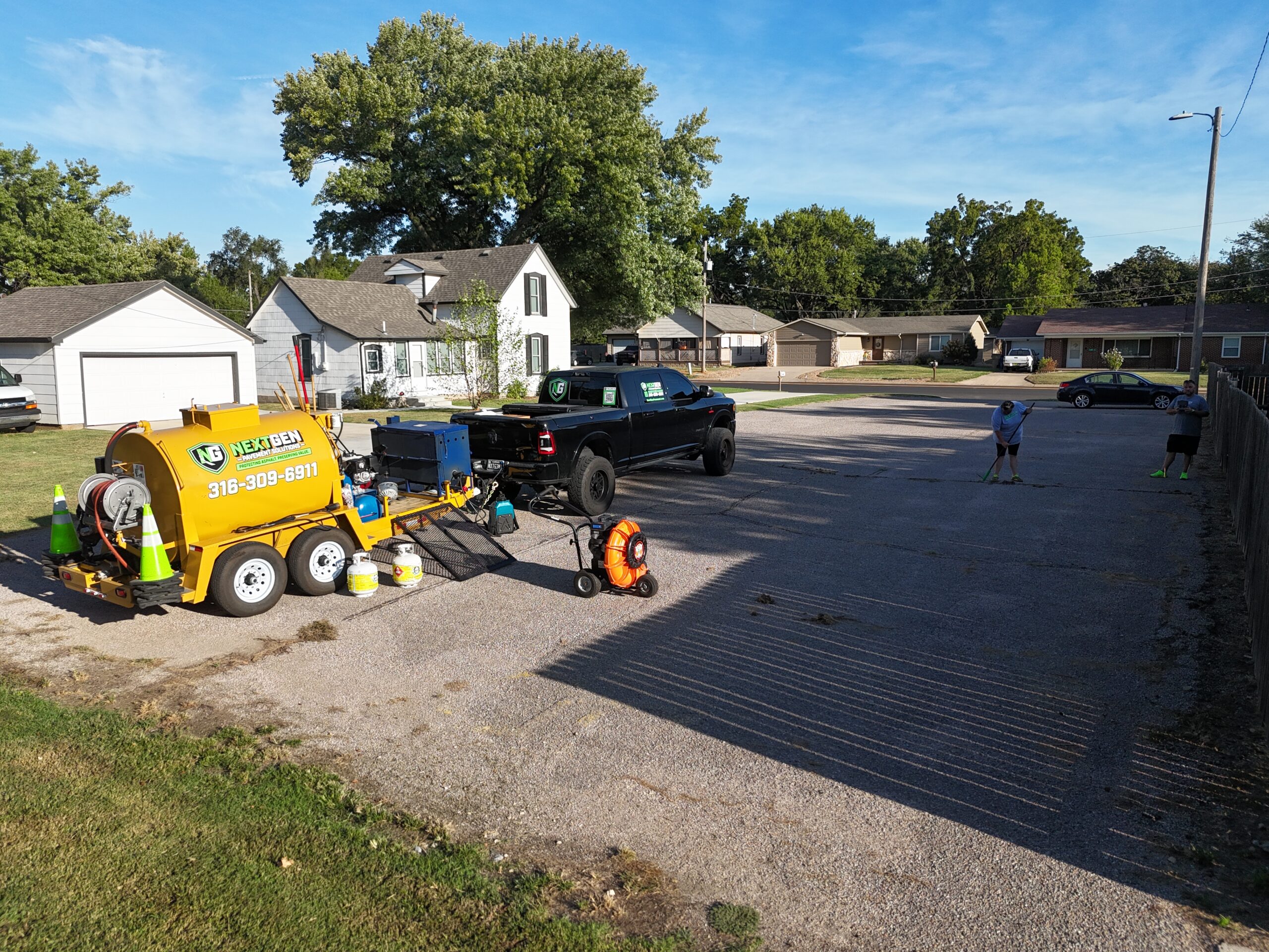 NextGen crew sweeping the Grace Communion Derby parking lot before crack sealing and sealcoating
