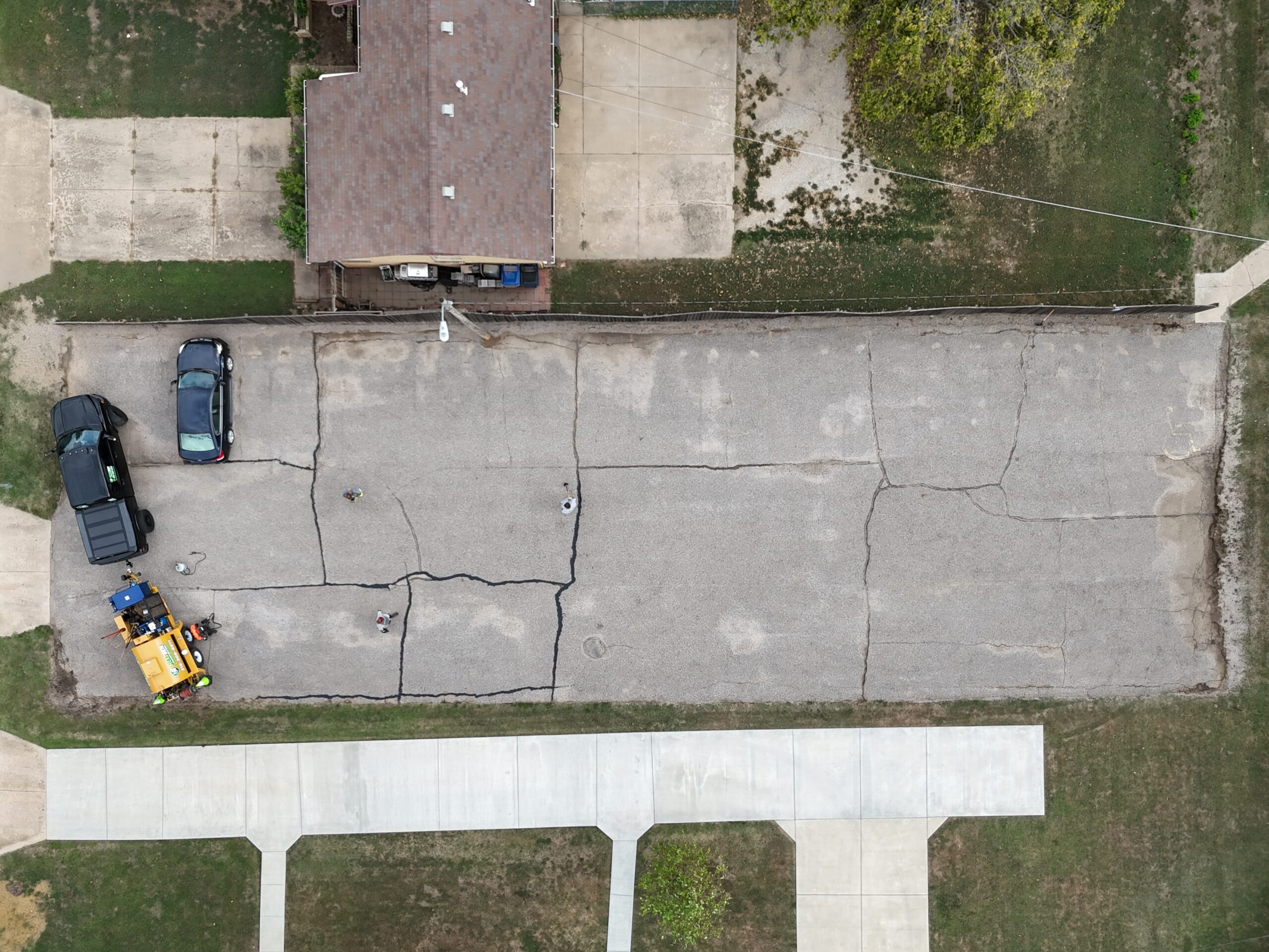 Aerial view of crack sealing in progress at the Grace Communion Derby parking lot before sealcoating