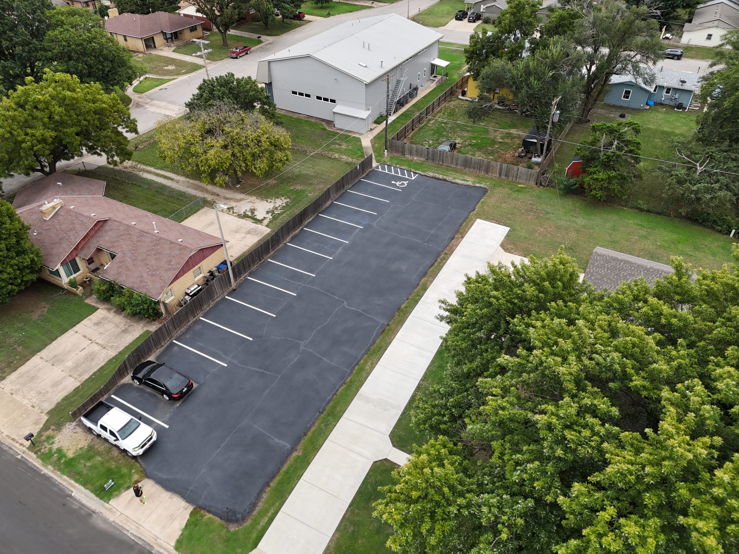 Oblique aerial view of the completed sealcoating and striping at Grace Communion Derby in Derby, Kansas.