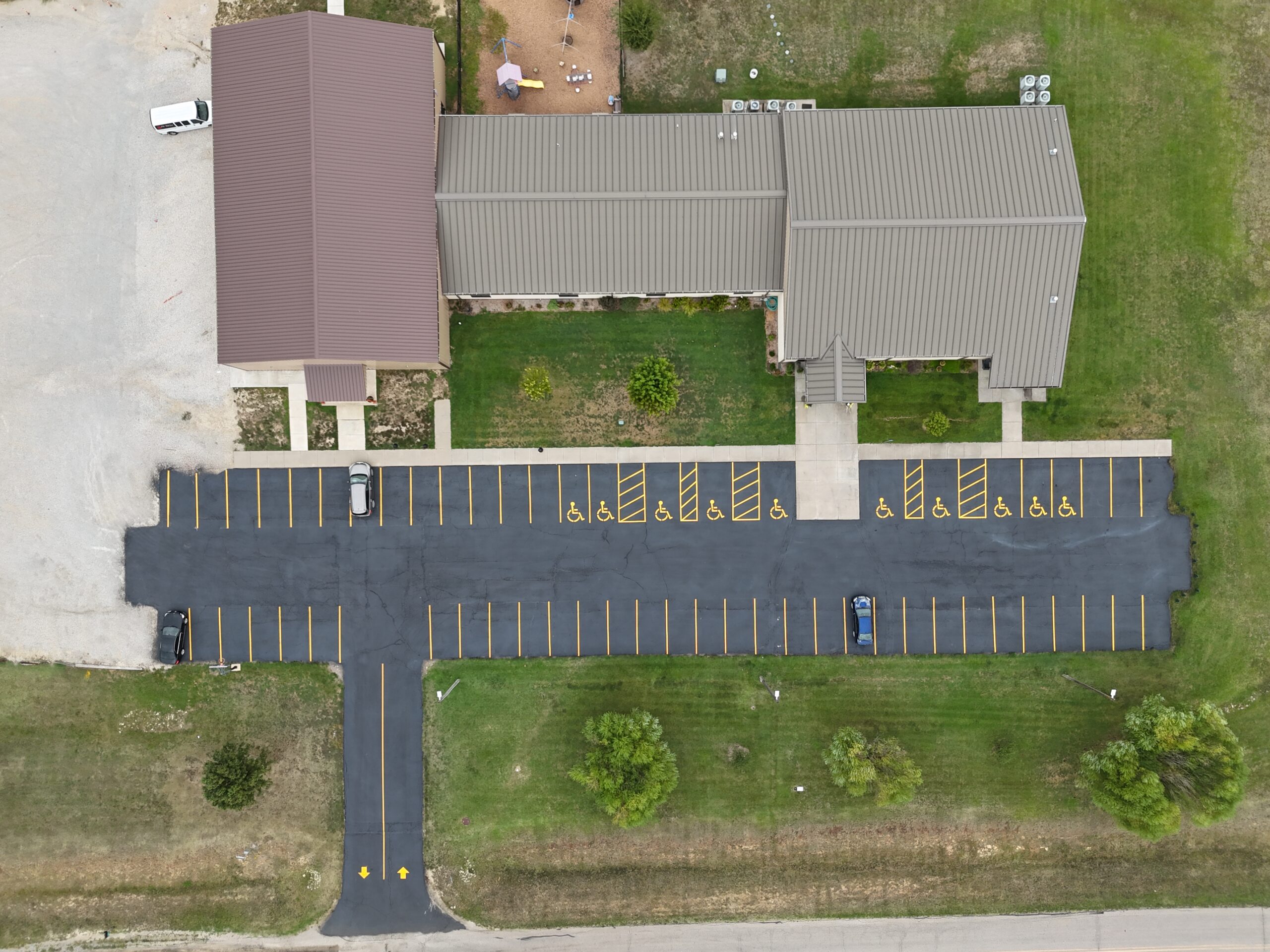 Top-down September 21 view of the Freedom Church parking lot with yellow parking stalls, access markings and directional arrows