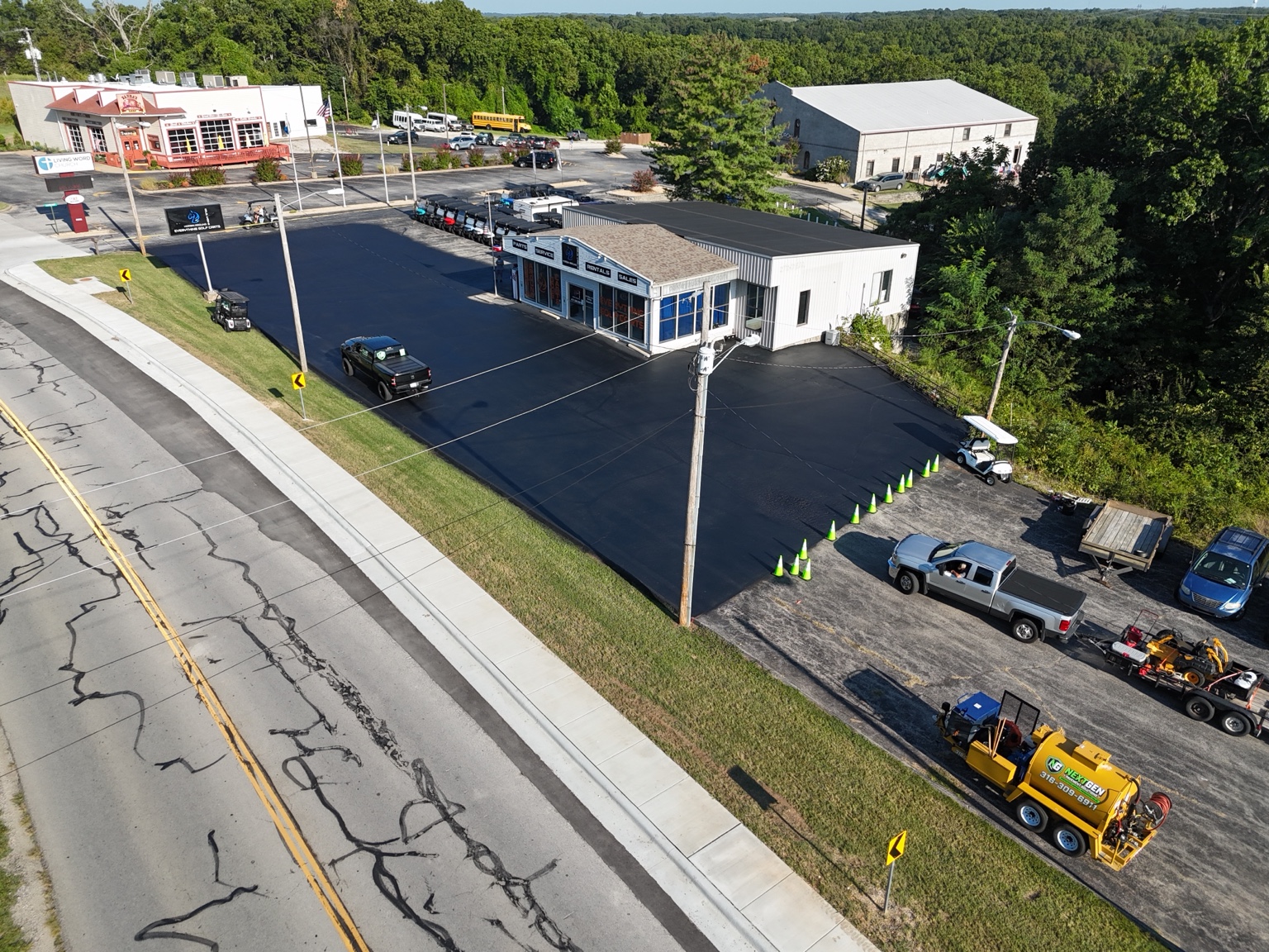 Angled aerial view of the sealed front lot and NextGen equipment at Horsin Around Golf Carts.