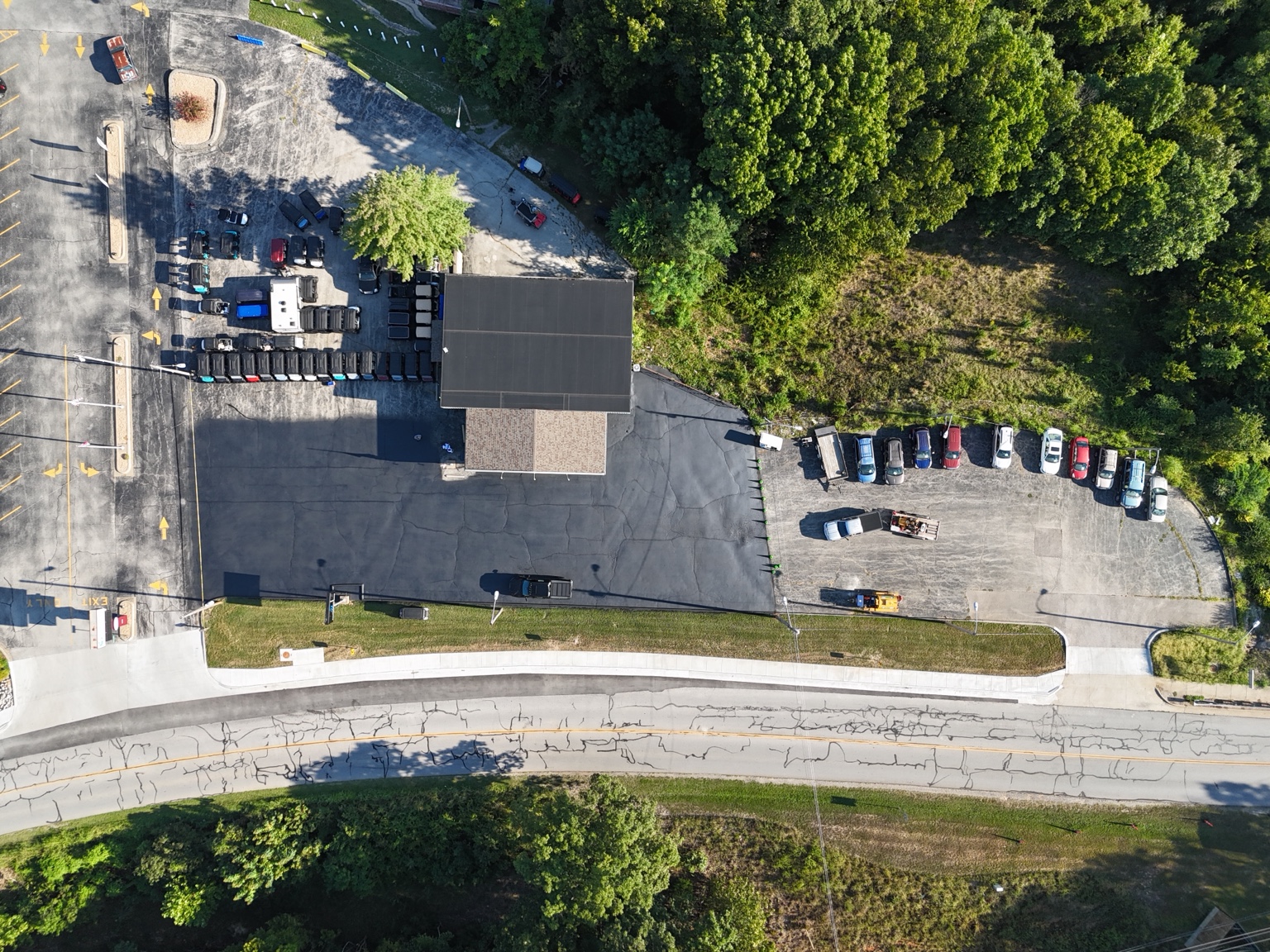 Overhead view of Horsin Around Golf Carts with its freshly sealed front lot beside lighter existing pavement.