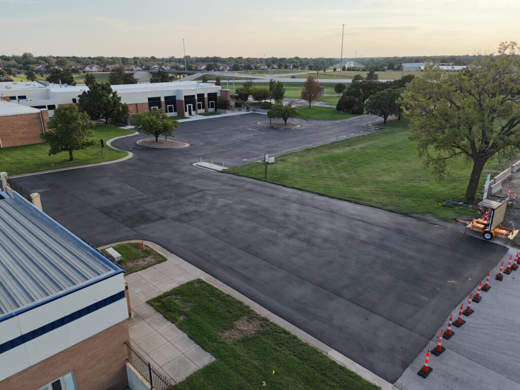 KTA Wichita Headquarters Sealcoating Freshly sealcoated pavement around the KTA DriveKS Customer Service Center with traffic cones at the entrance