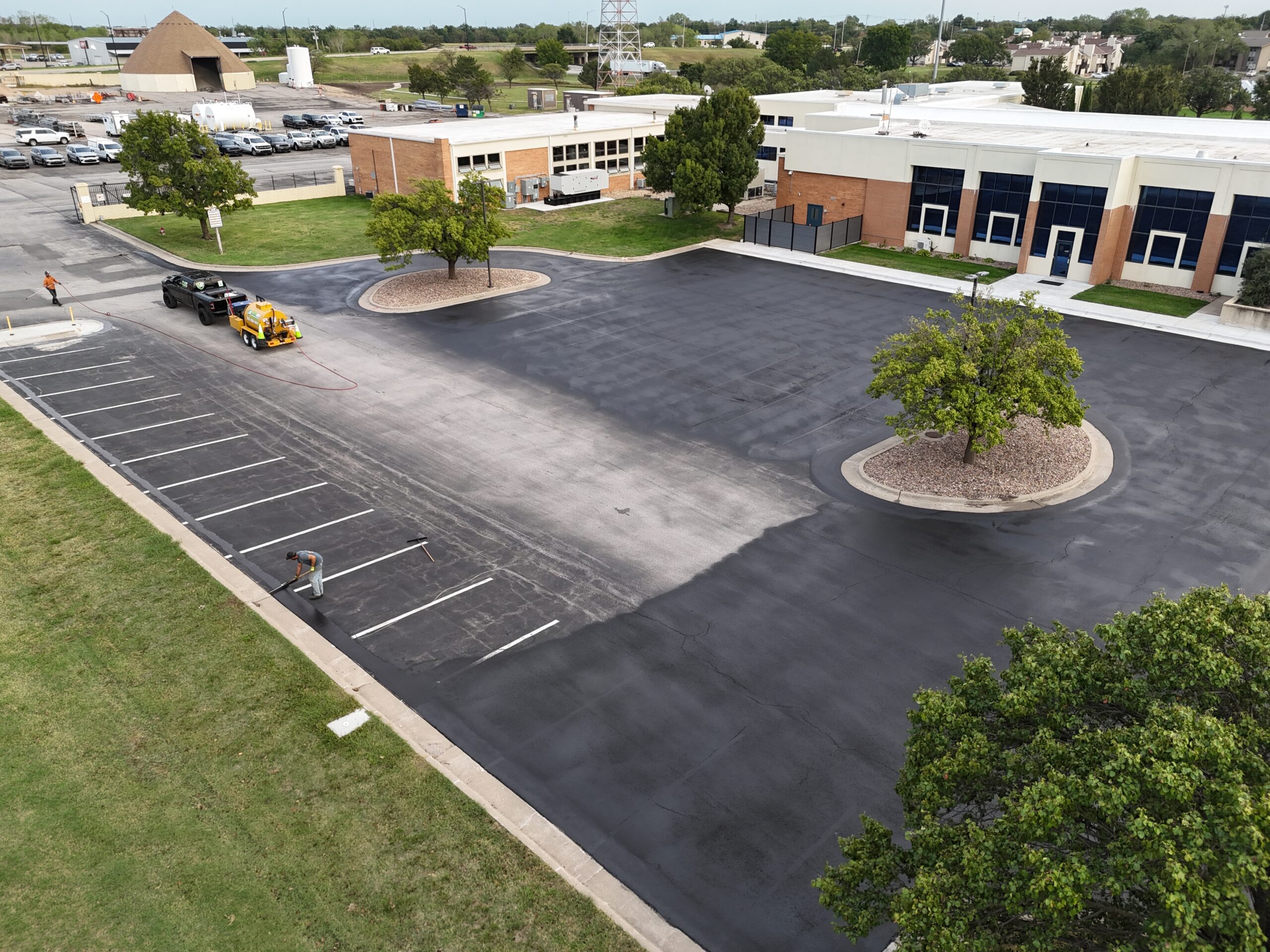 KTA Wichita Headquarters Sealcoating NextGen crew working along the parking area at KTA's Wichita headquarters with sealcoating equipment on site