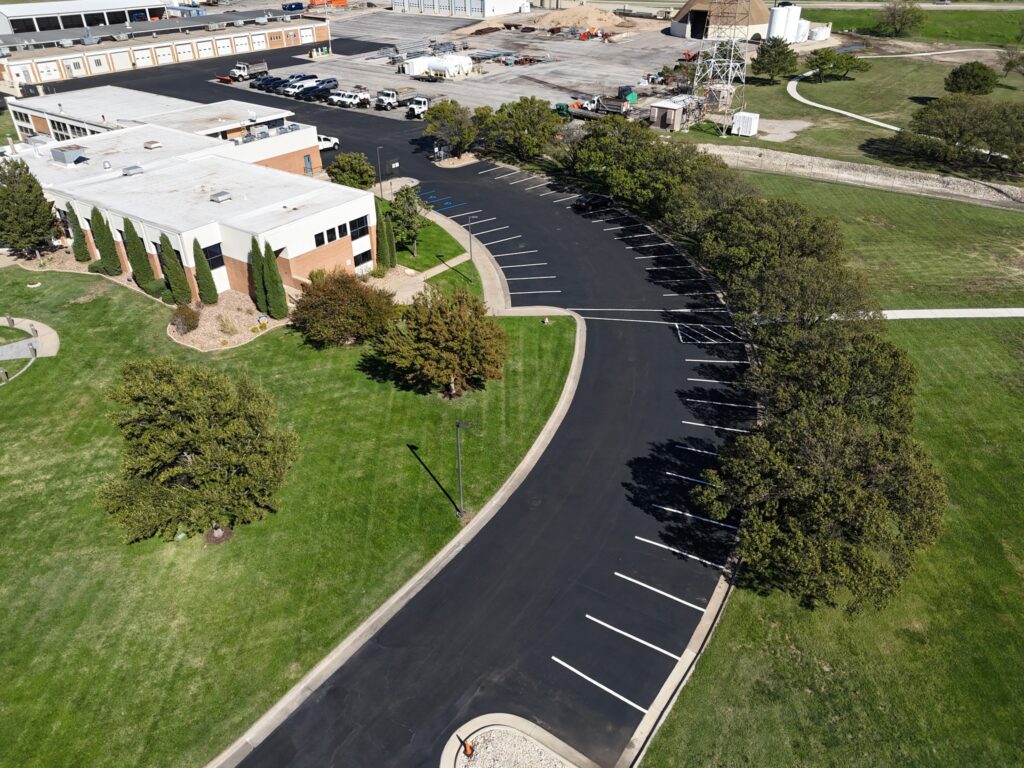 KTA Wichita Headquarters Sealcoating Aerial view of the curved parking area at KTA Wichita headquarters with completed white parking stripes.