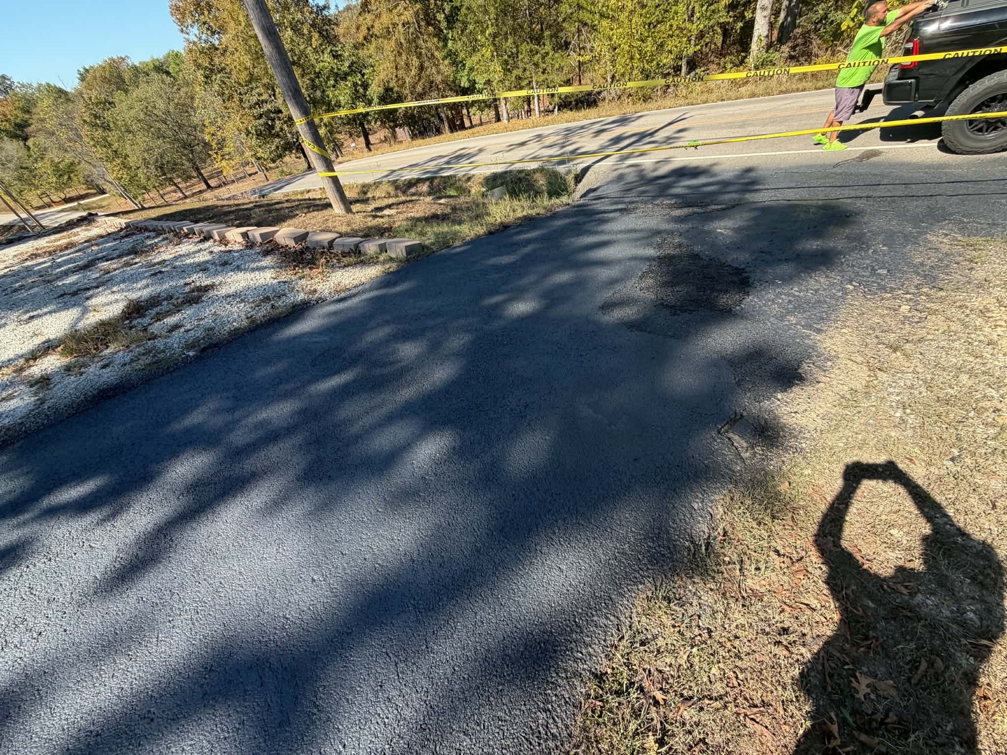 Driveway approach after localized temporary cold-mix patching and coating.