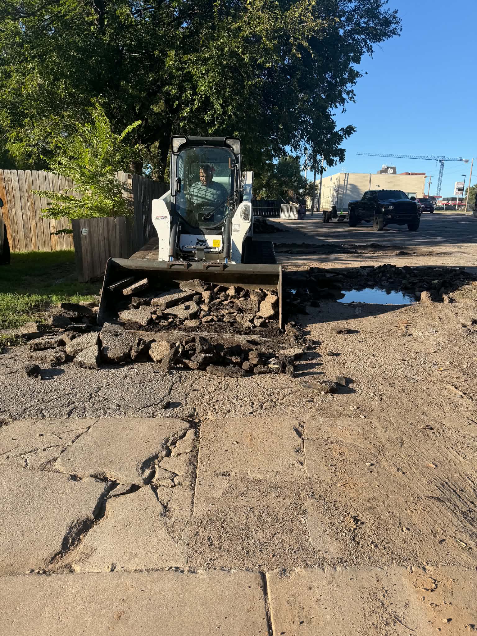 College Hill Pediatrics | Asphalt Repair & Sealcoating in Wichita Bobcat equipment removes damaged asphalt at College Hill Pediatrics