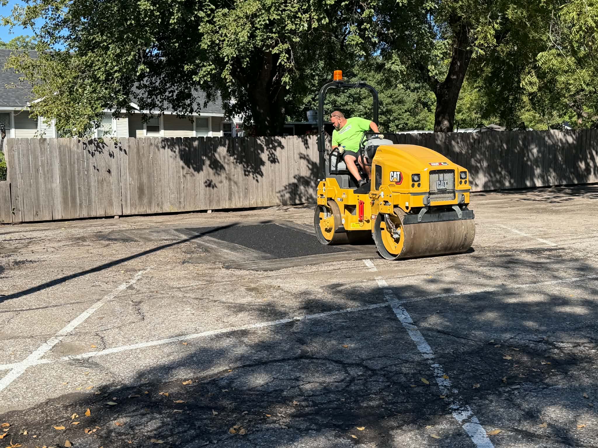 CAT roller compacts an asphalt repair at College Hill Pediatrics